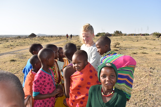 Tanzaniaanse kinderen met een dochter van een familie op safari door Tanzania